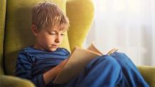 Young boy reading in a chair